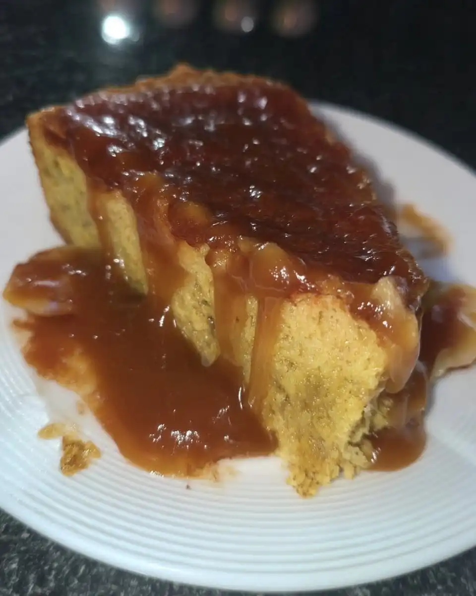 Serving spoon lifting a piece of banana pudding poke cake from the pan