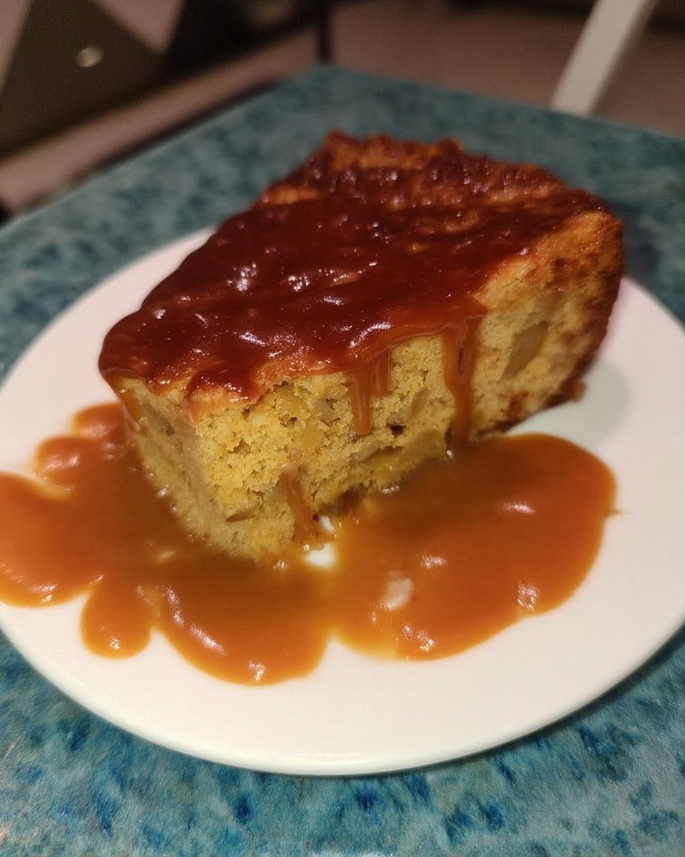 Slice of banana pudding poke cake on a white plate with nilla wafer crumbs