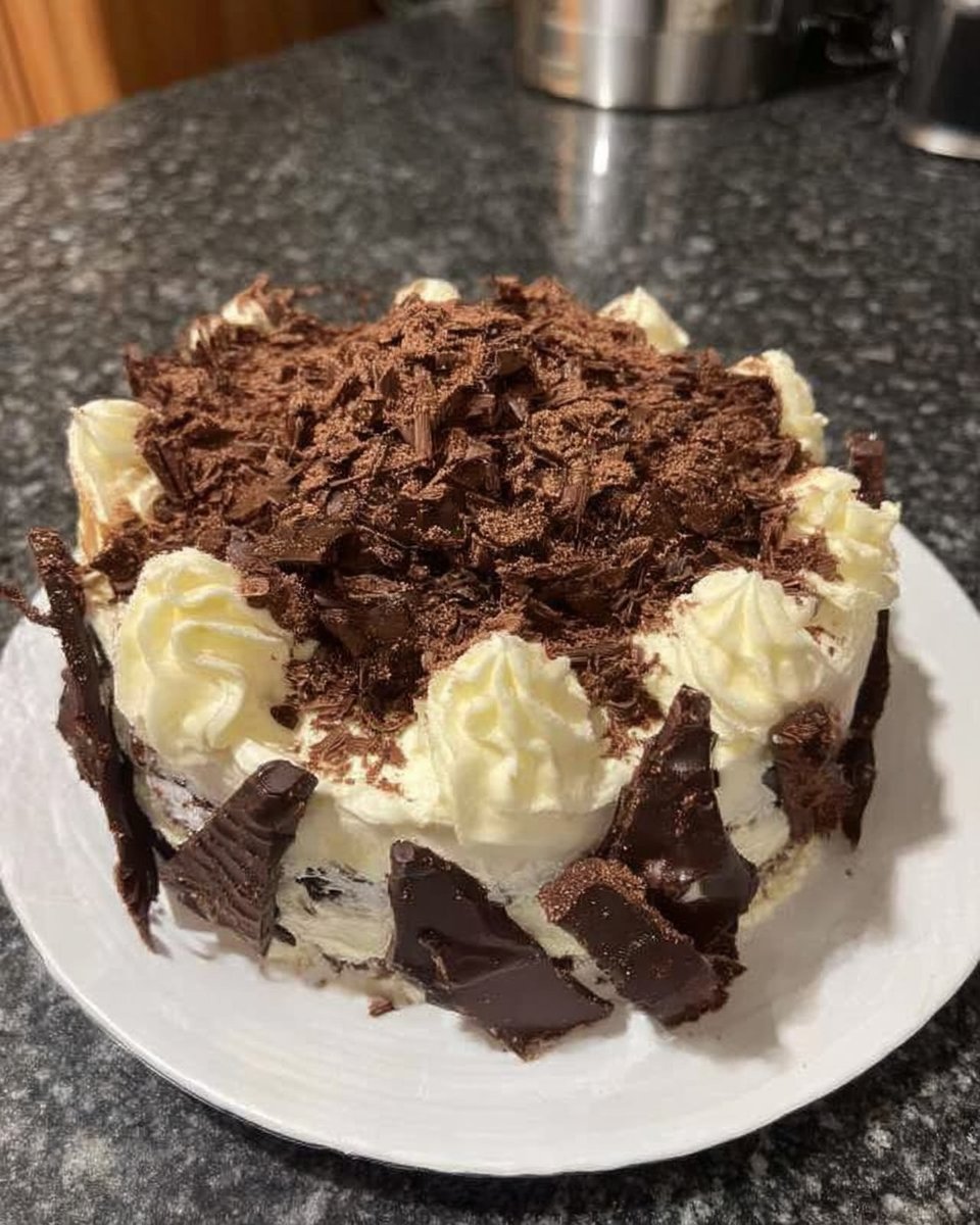 Pastry brush applying cherry liqueur to chocolate sponge cake layer