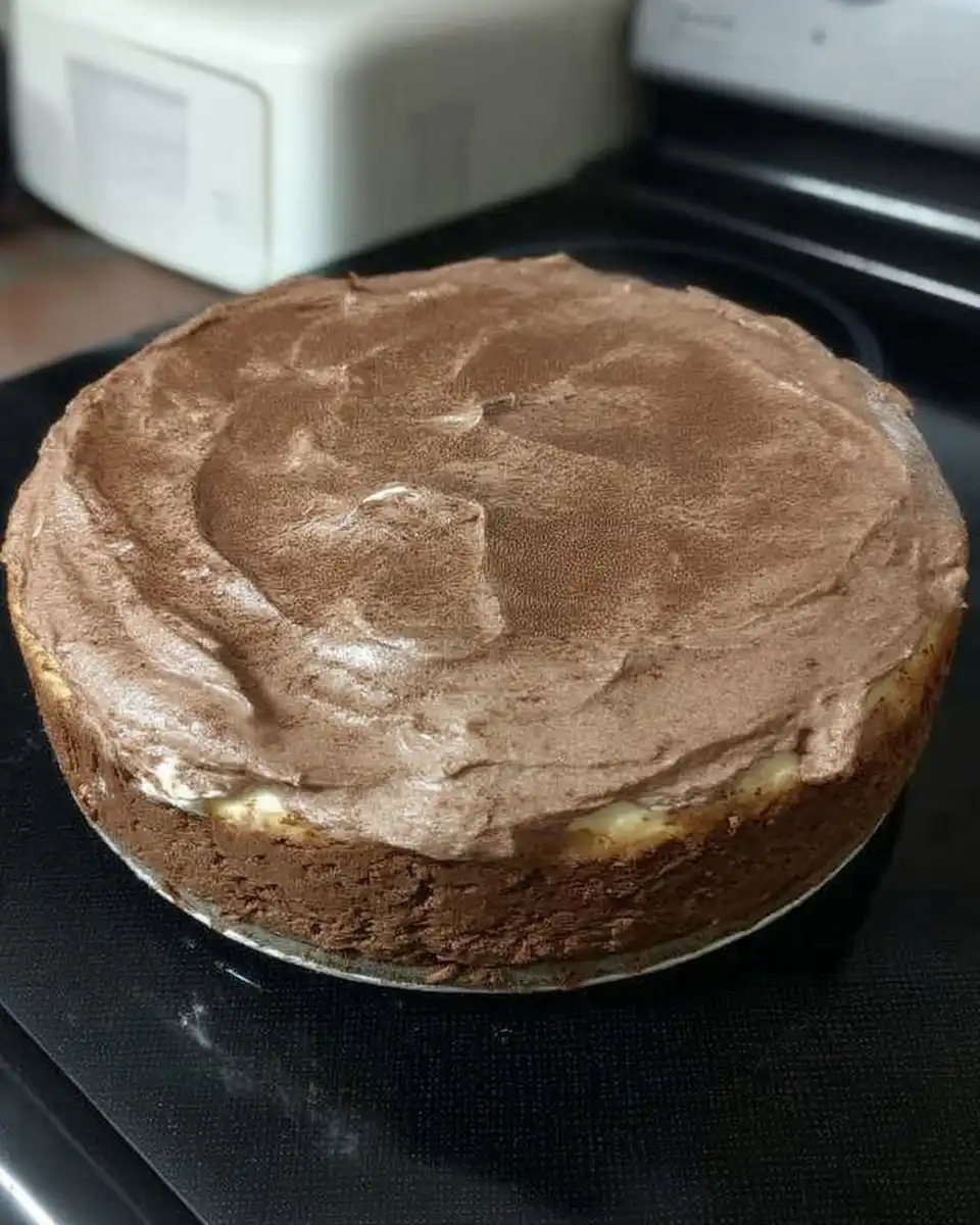 Chocolate cheesecake baking in a water bath inside the oven