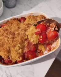 Slice of 3 ingredient dump cake with cherry filling and golden butter crust on a white plate