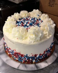 Top down view of a classic flag cake decorated with fresh raspberries and blueberries