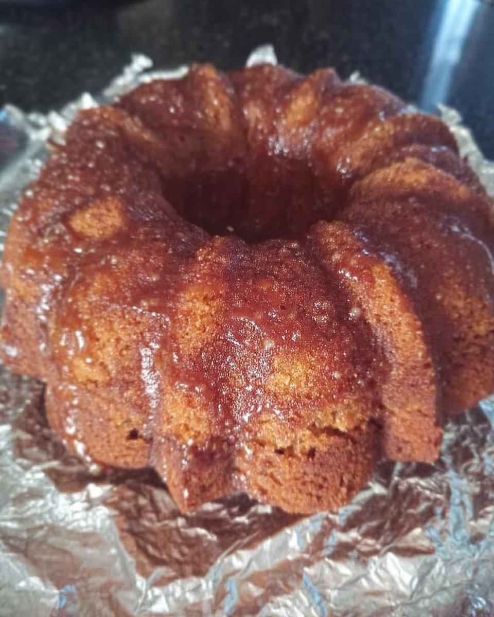 Whole classic vanilla bundt cake on a ceramic cake stand with powdered sugar