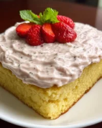 Slice of classic vanilla cake with white buttercream on a ceramic plate
