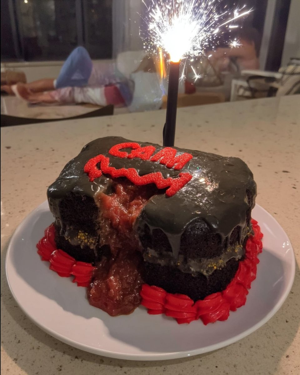 Cutting batman shapes out of black sheet cake with a cookie cutter