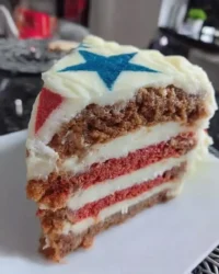 Slice of red white and blue cake with fresh berries and chantilly cream