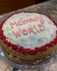 Slice of fluffy white Mothers Day cake topped with swirls of chocolate and vanilla buttercream
