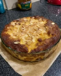 A warm serving of peach dump cake with golden crust and vanilla ice cream