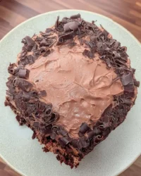 Slice of pink champagne cake with blue water ganache drip on a white plate