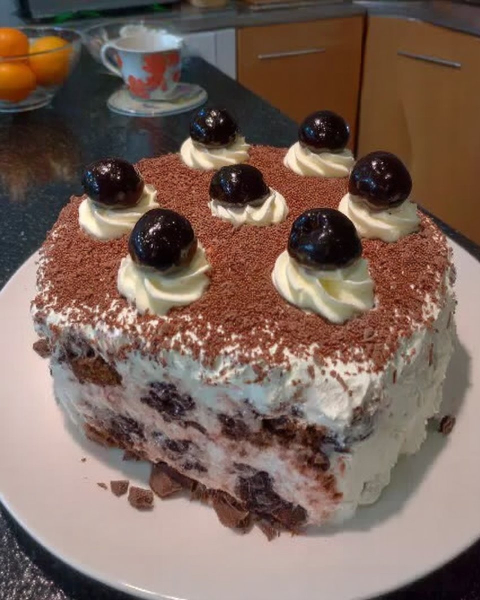 Piping whipped milk chocolate ganache onto a cocoa chiffon sponge layer