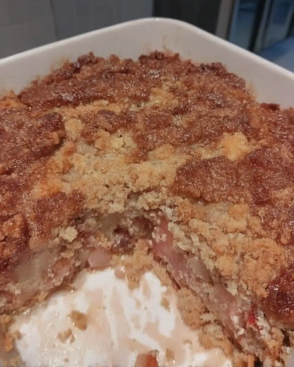 Pouring milk and butter glaze over a poked strawberry rhubarb cake