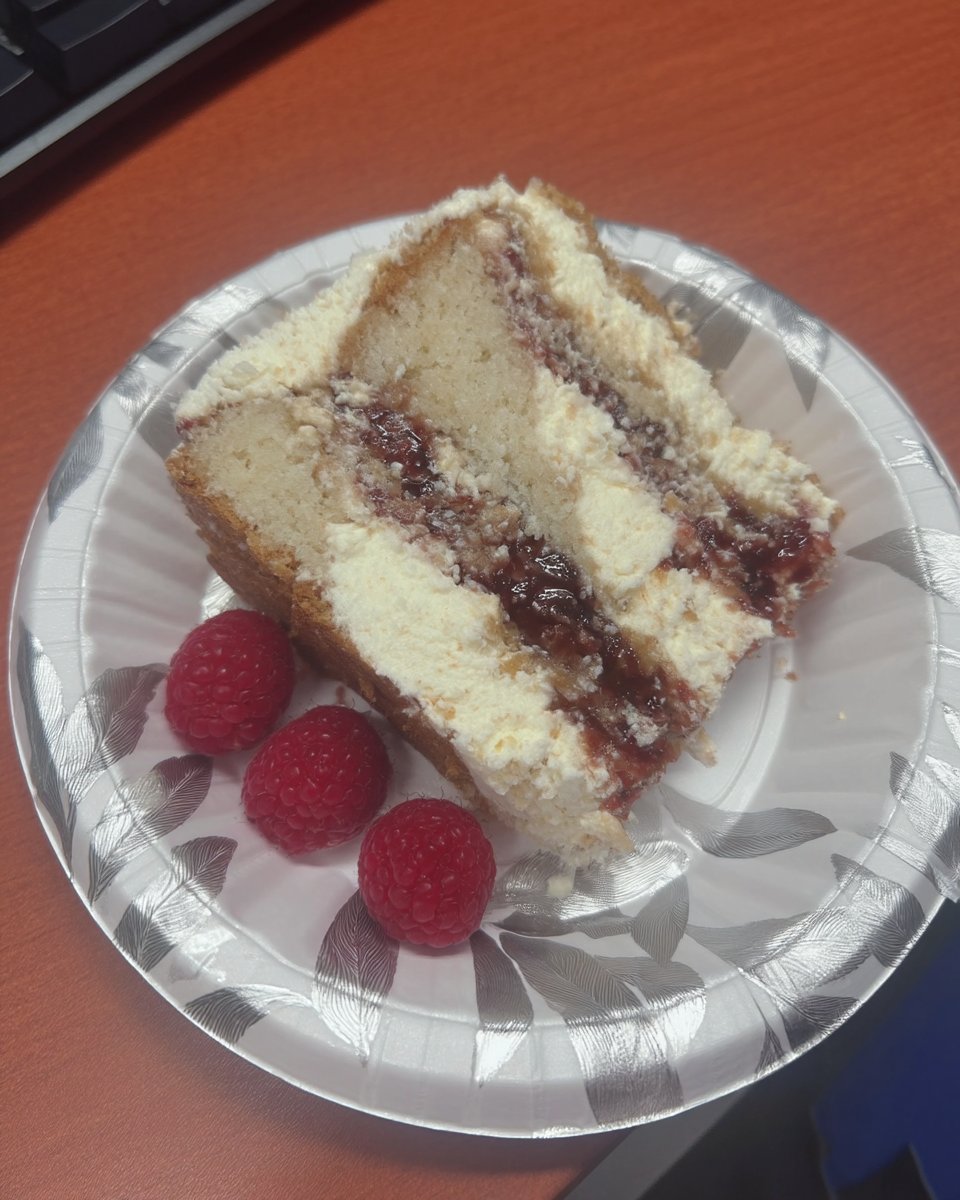 Slice of raspberry white chocolate cake showing fluffy layers and whipped ganache