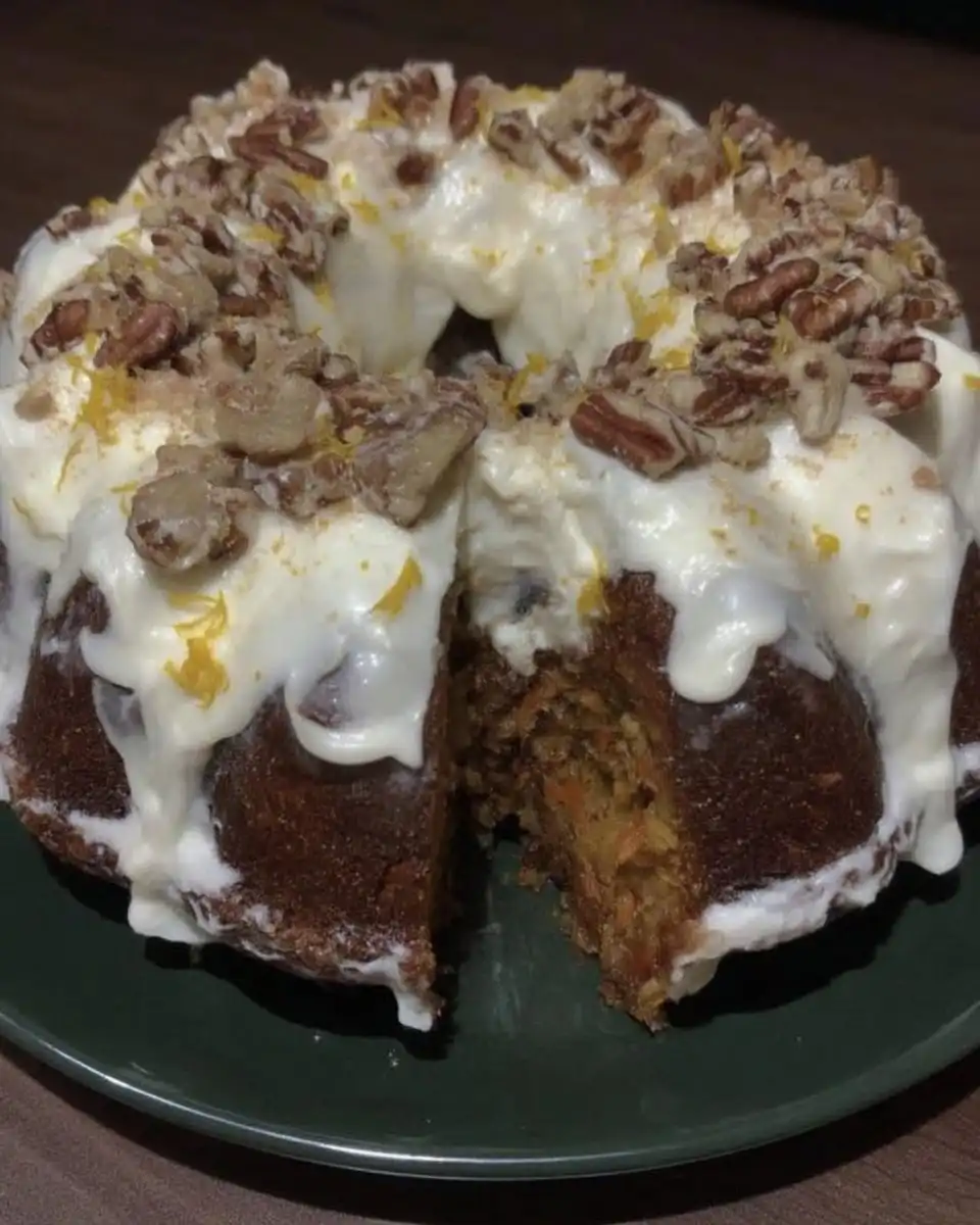 Carrot cake slice served on a vintage floral plate with a fork.