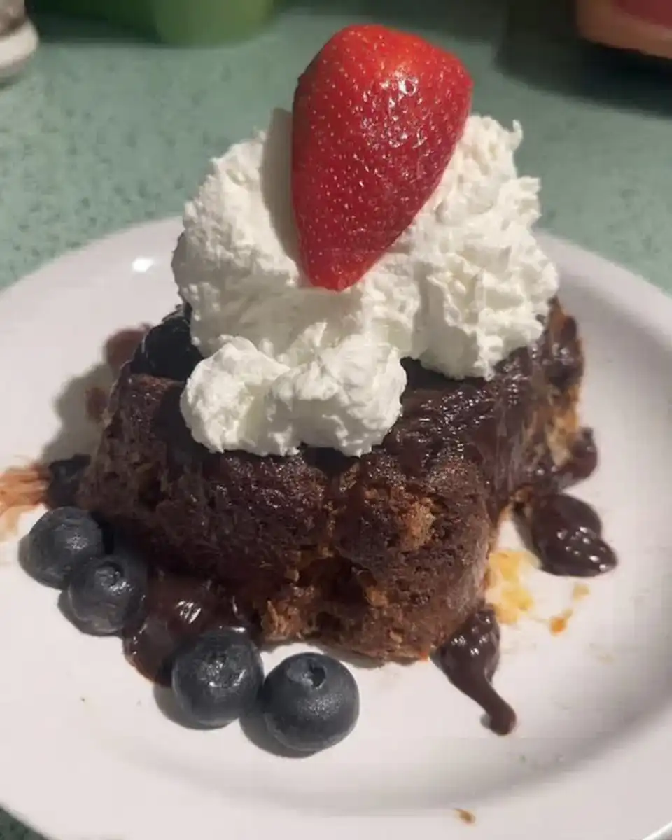 A slice of hazelnut chocolate cake on a plate next to a cup of espresso