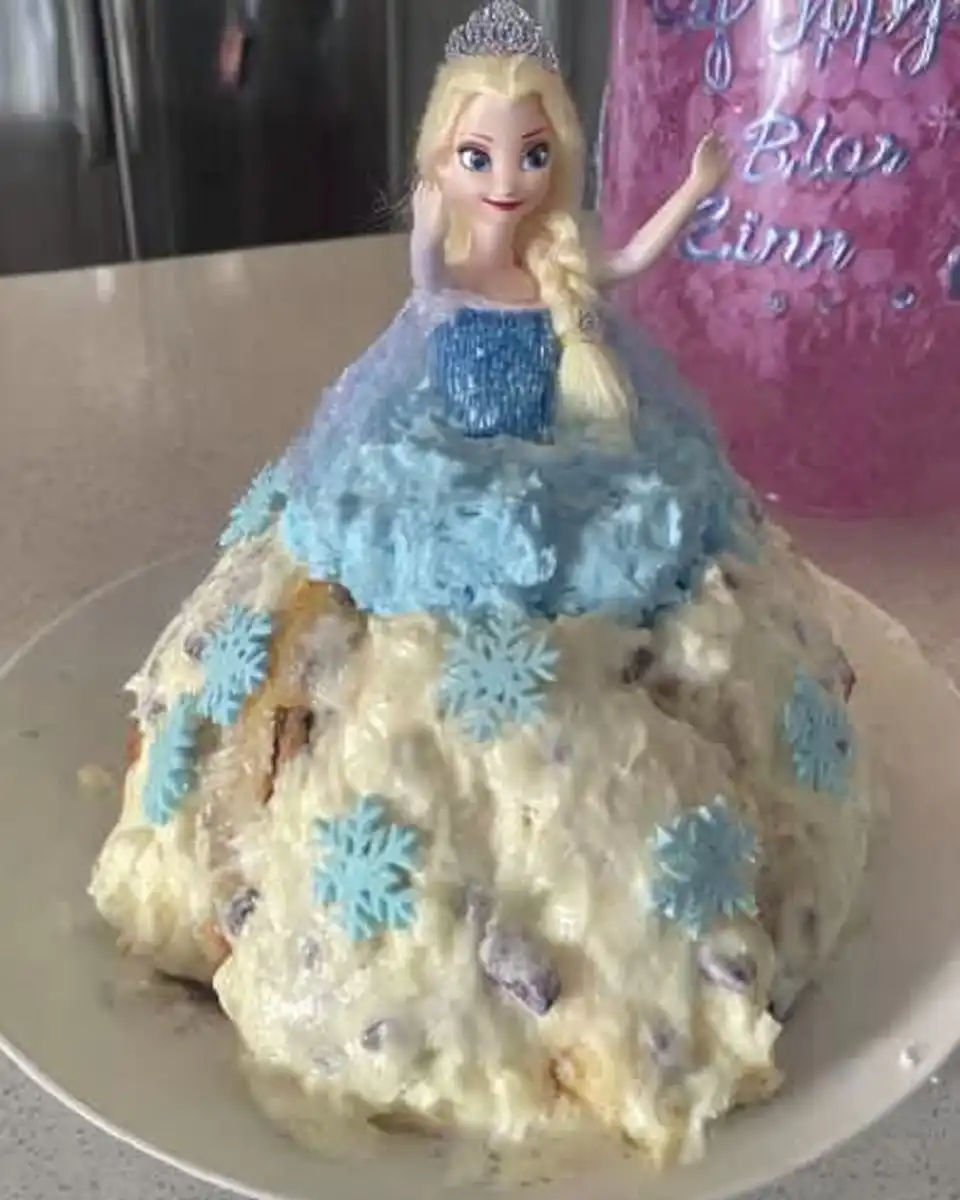 Slice of princess cake showing layers of cream and jam on floral china