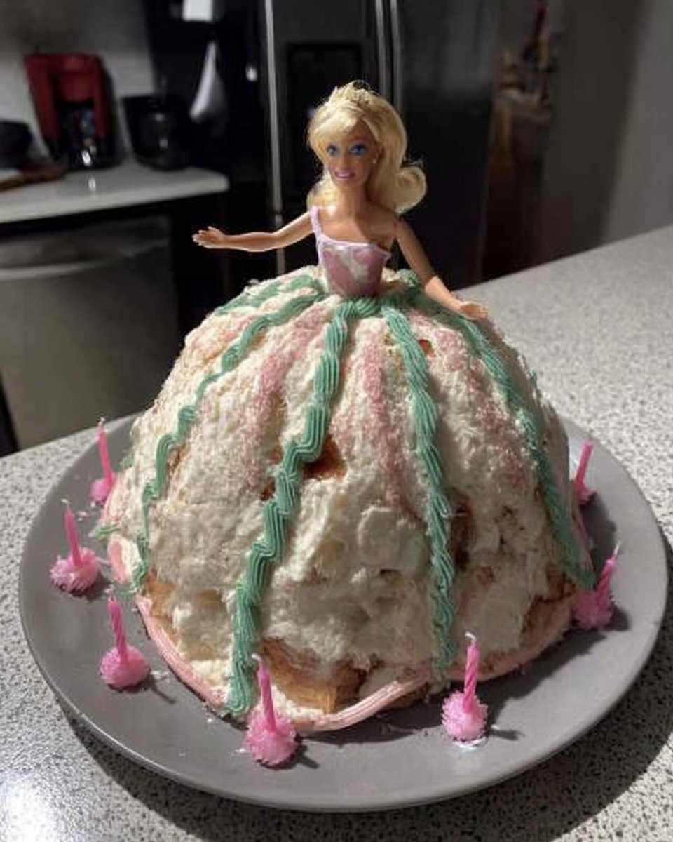 Barbie Cake 14 Slice of yellow cake with pink frosting on a floral dessert plate