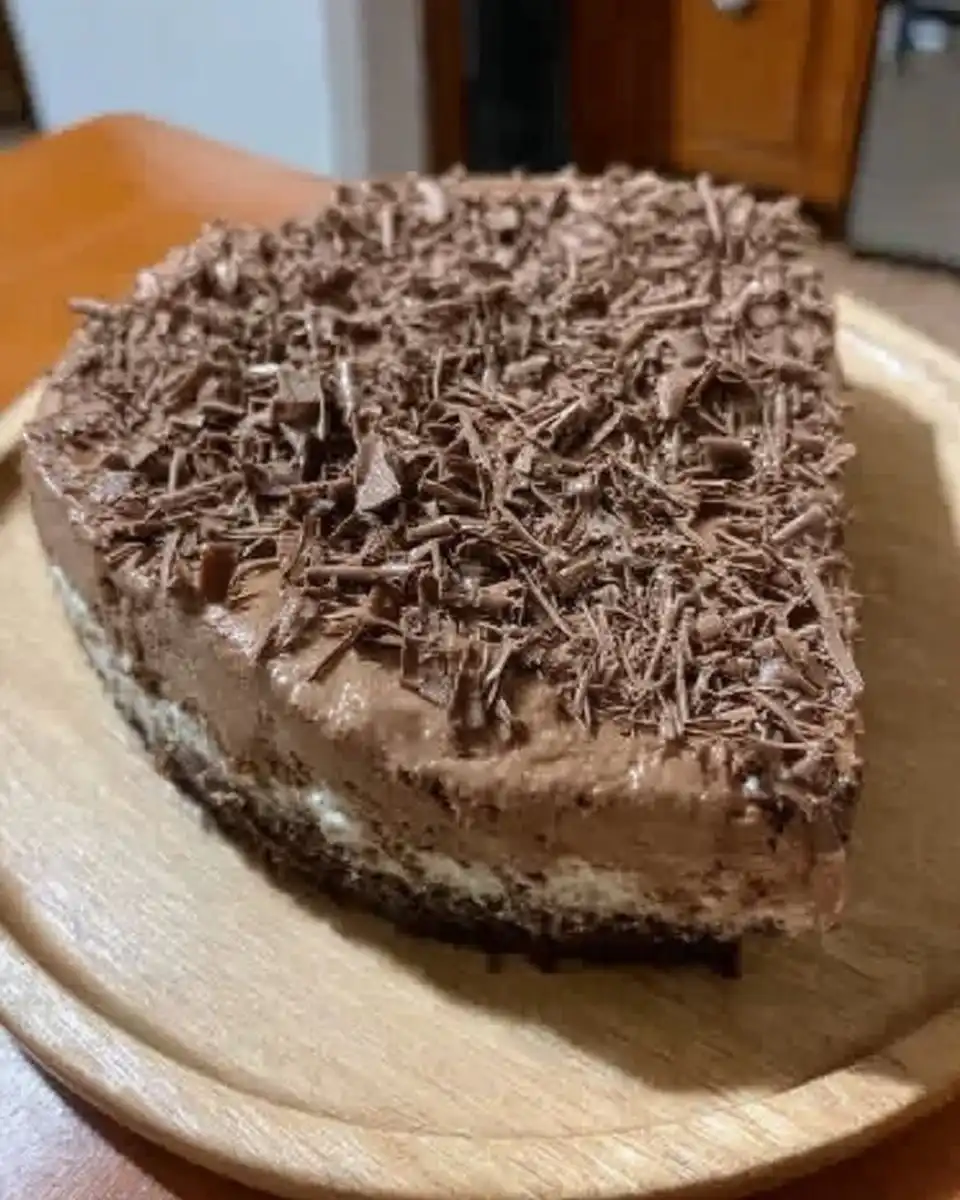 Whole chocolate cheesecake with ganache topping being sliced with hot knife