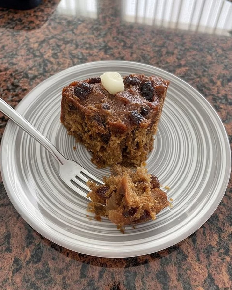Thin slice of dense fruitcake on a floral vintage china plate