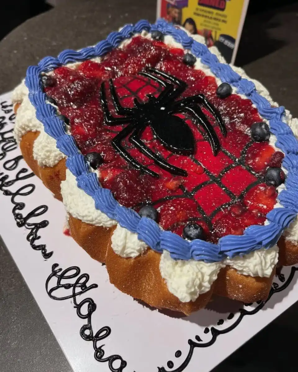 Spider Man Cake 10 Top down view of a red fondant Spider Man cake face with large white eyes