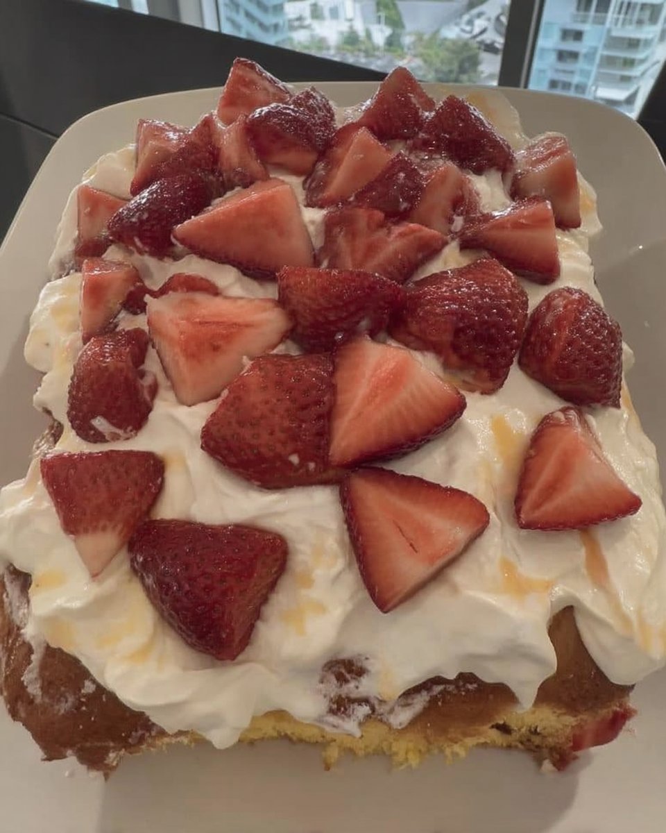 Square slice of strawberry poke cake served on a vintage floral plate