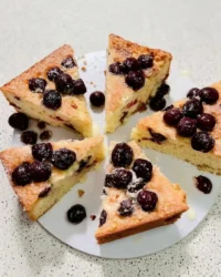 Slice of fresh cherry cake on a vintage floral plate with a fork