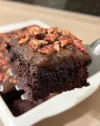 Slice of old fashioned chocolate cake on a vintage floral plate with a fork