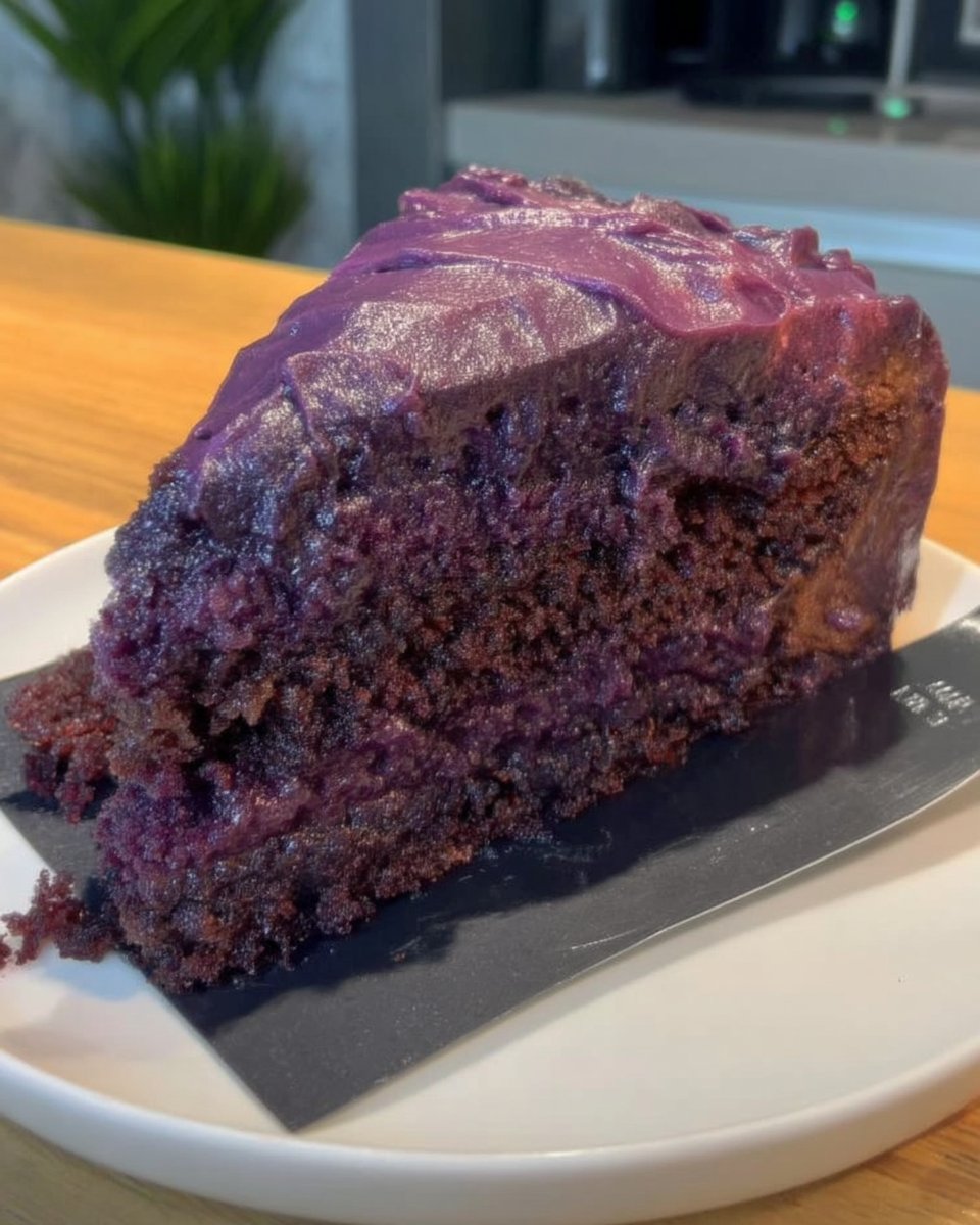Slice of purple carrot cake on a vintage lace doily with a fork