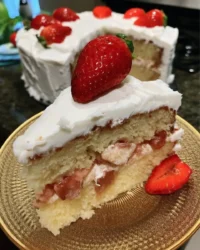 Whole strawberry vanilla cake on a vintage glass stand with fresh berries