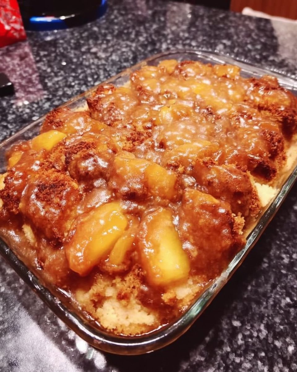 Whole peach cake on a stand next to a cup of black coffee