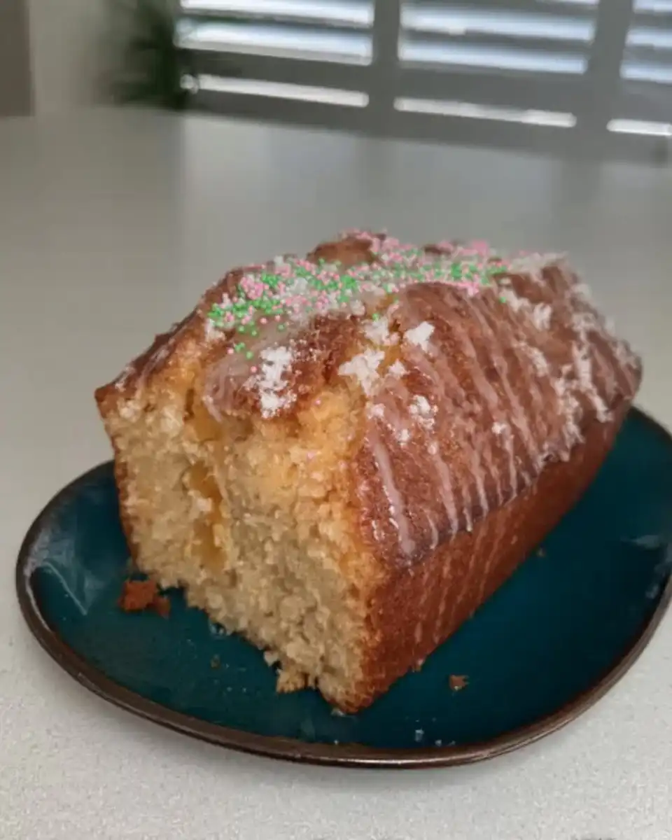 Hands zesting a lemon into a bowl of white sugar