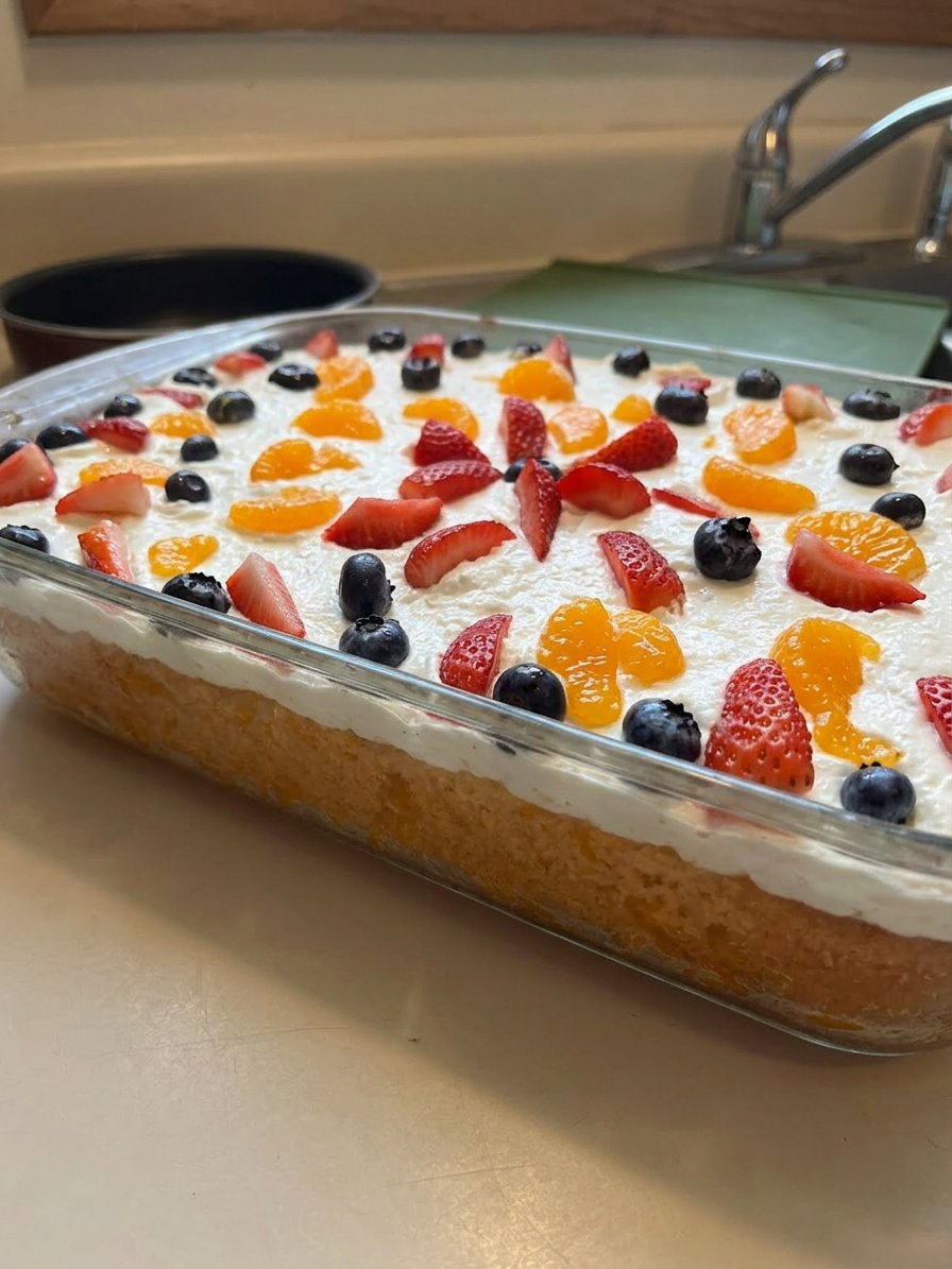 A close up view of a sliced Mandarin Orange Cake with thick pineapple frosting.