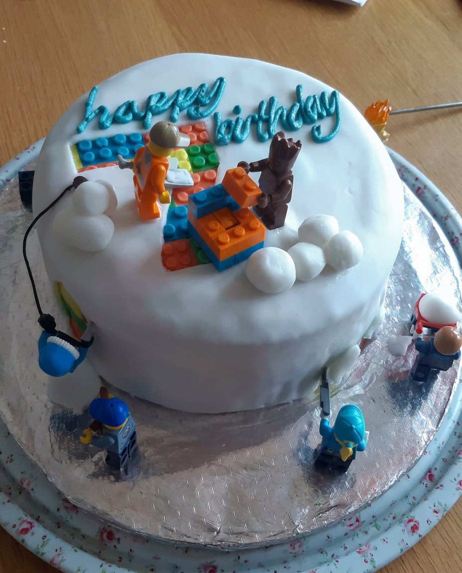 A large rectangular boys cake decorated like a green soccer pitch with white lines and player figurines