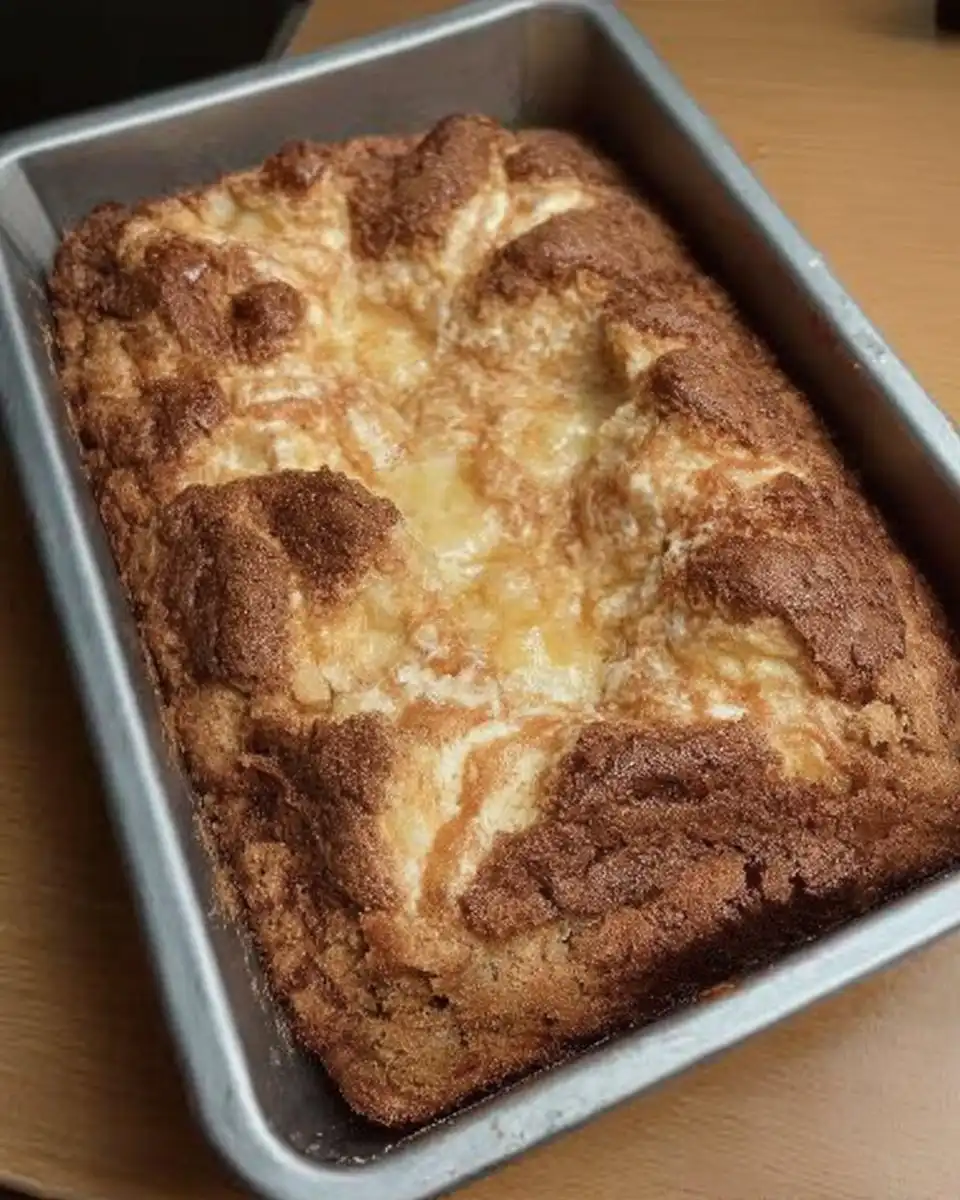 A square of gooey butter cake served next to a steaming cup of coffee