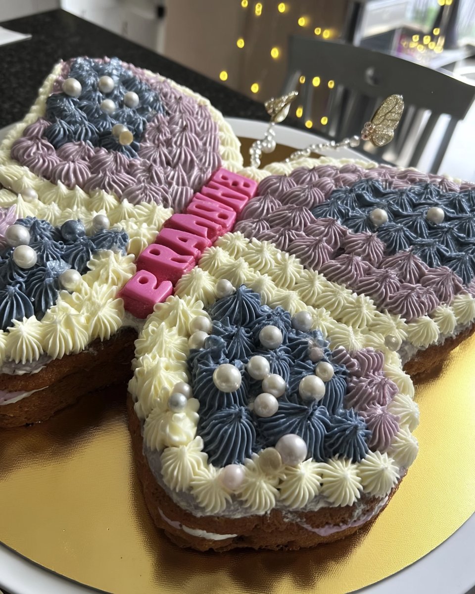 Close up of a hand placing sponge wings into buttercream