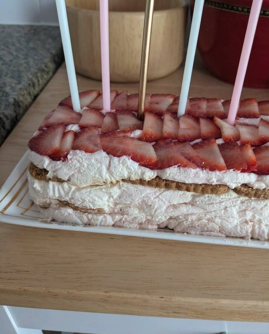 A silver mixing bowl filled with stiff whipped cream and a whisk attachment.