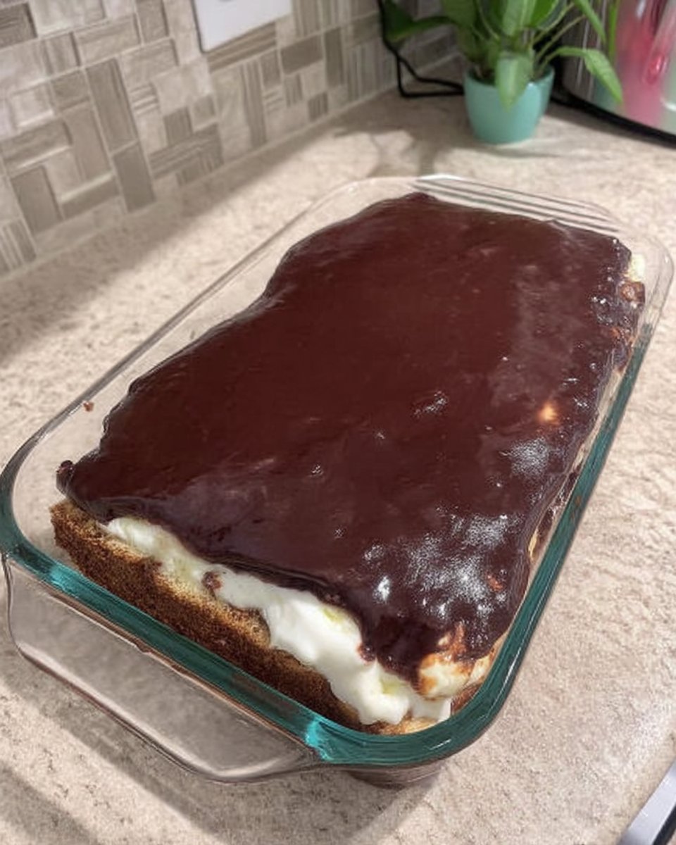 Chocolate Eclair Cake 13 Spreading smooth chocolate frosting over a layer of graham crackers.