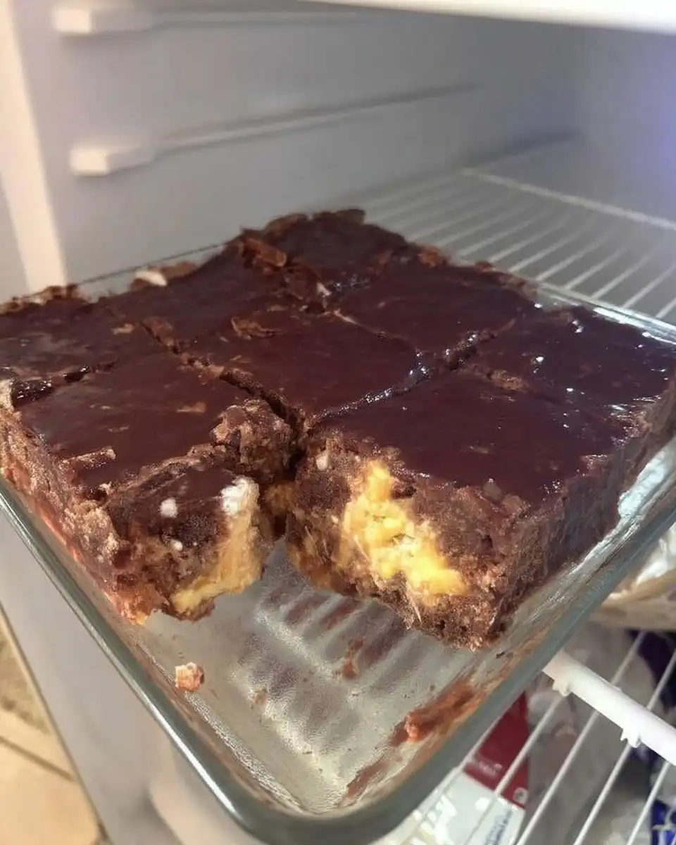 A slice of chocolate eclair cake served on a modern white plate with a fork.