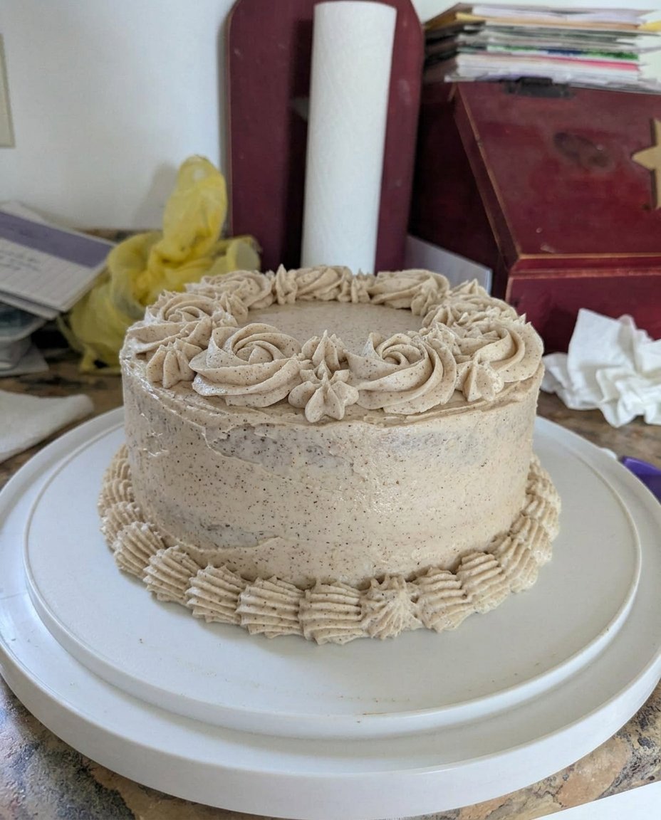 A close up of a chocolate poke cake topped with whipped cream and snickers
