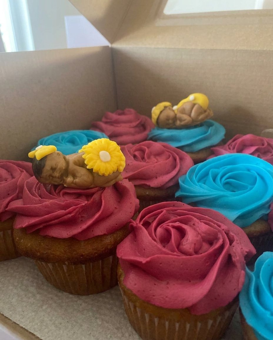 A tall chocolate cake topper standing upright in a thick layer of vanilla frosting on a round cake.