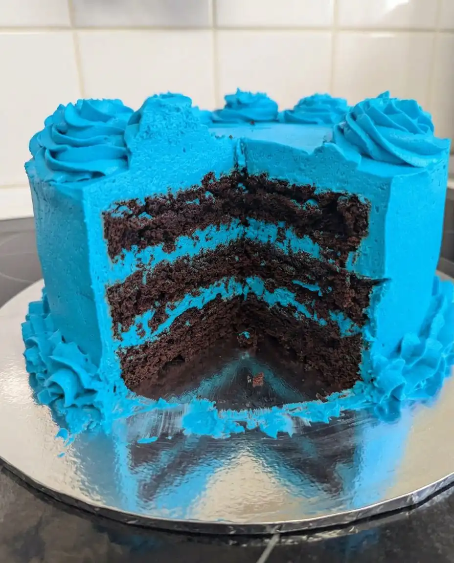 A whisk attachment lifting a stiff glossy peak of Swiss meringue buttercream