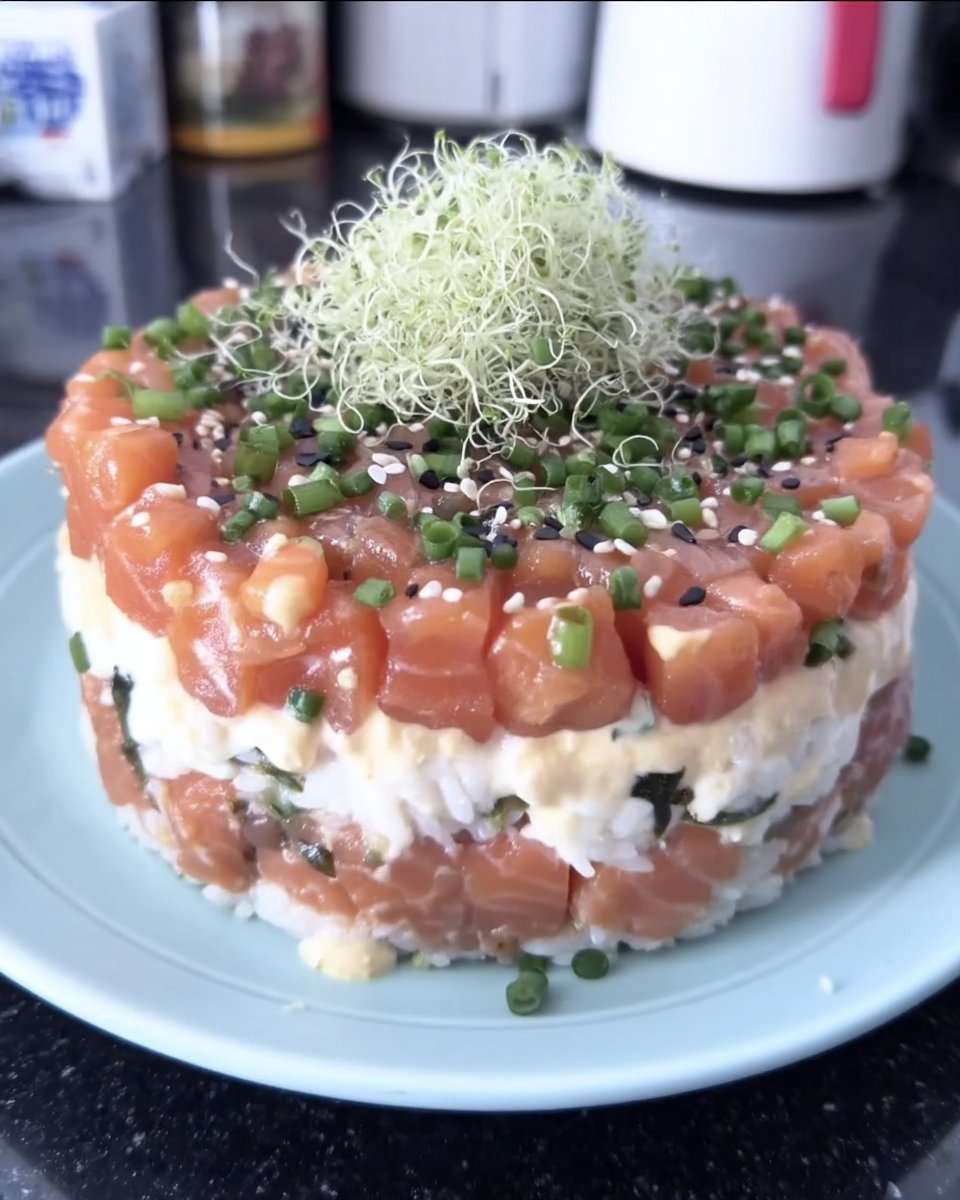 A stunning layered sushi cake with salmon avocado and cream cheese
