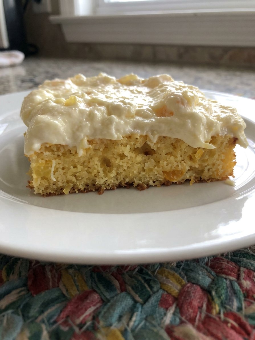 Cans of mandarin oranges and crushed pineapple next to a box of cake mix and eggs.