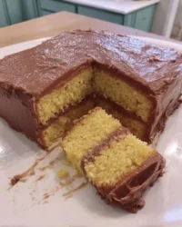 Two golden yellow cake layers resting on a wire cooling rack