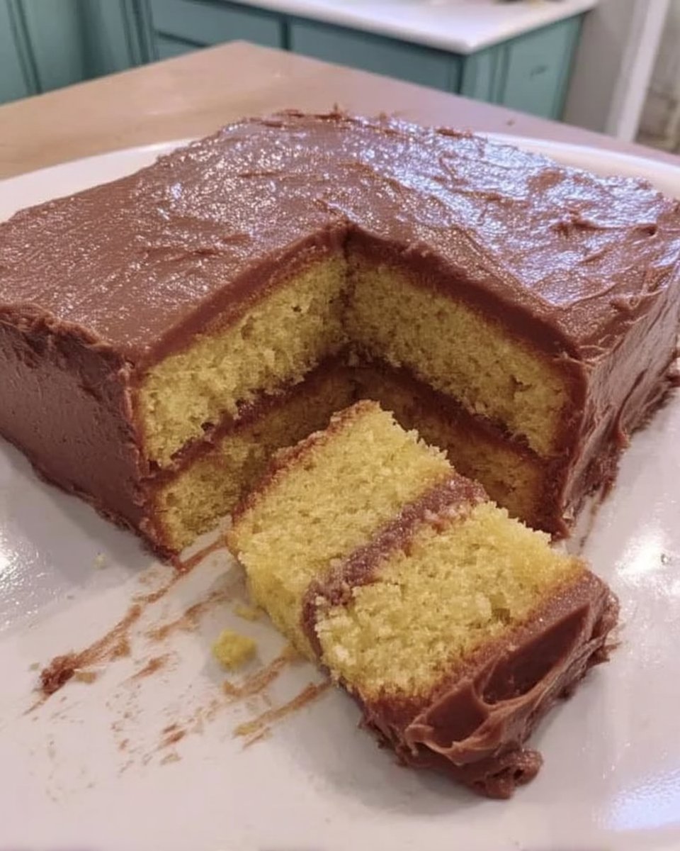 Two golden yellow cake layers resting on a wire cooling rack