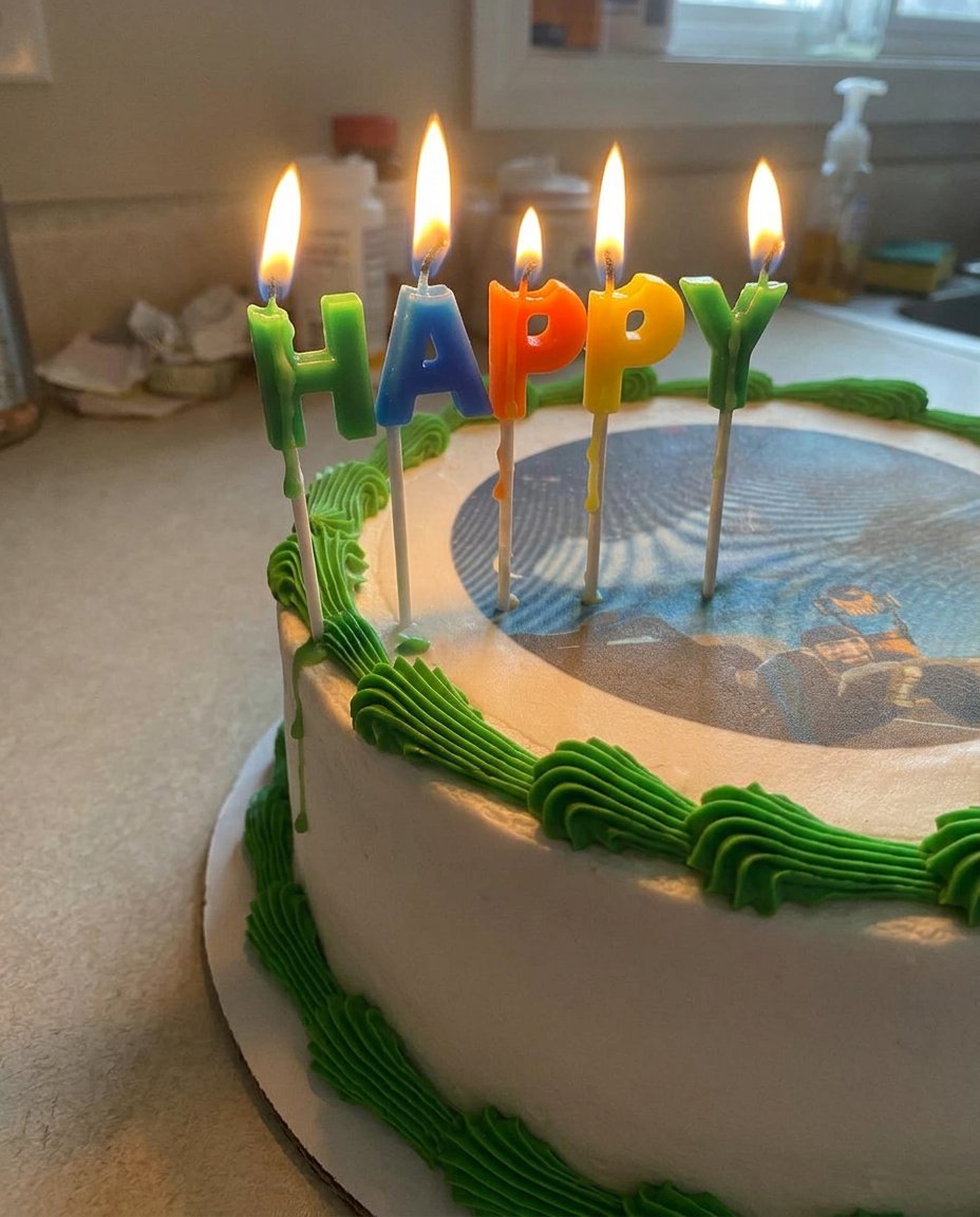 A photo cake presented on a white pedestal stand for a celebration