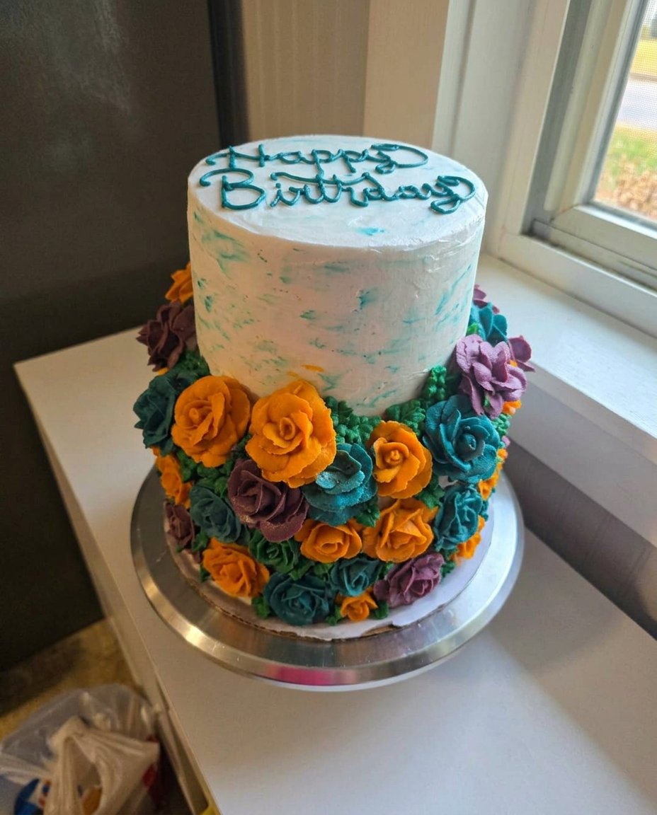 A wooden spoon handle poking holes into a warm chocolate cake