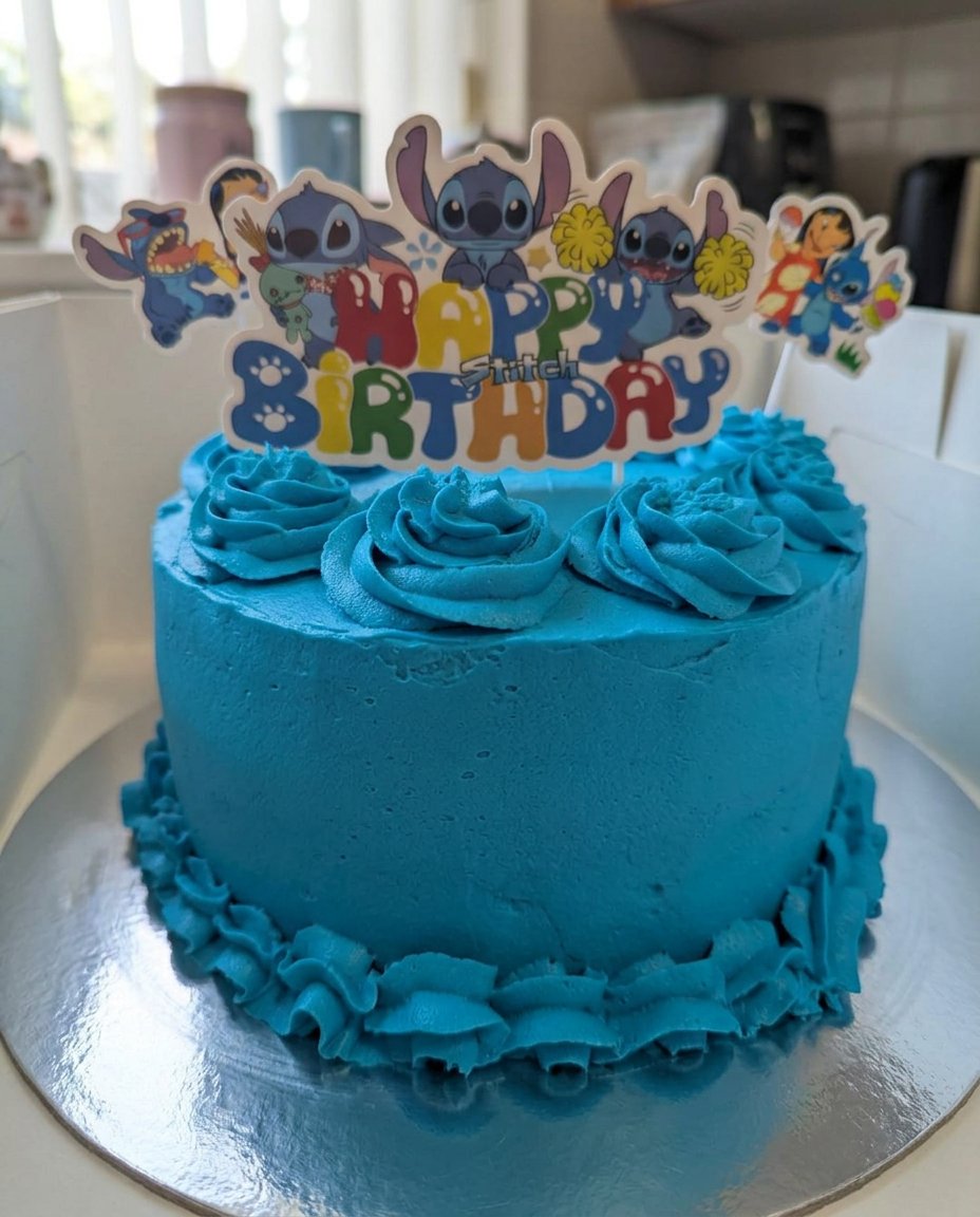 Two layers of dark chocolate sponge cake resting on a wire cooling rack