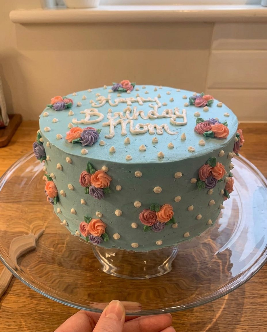 A slice of the floral birthday cake on a white plate with a fork