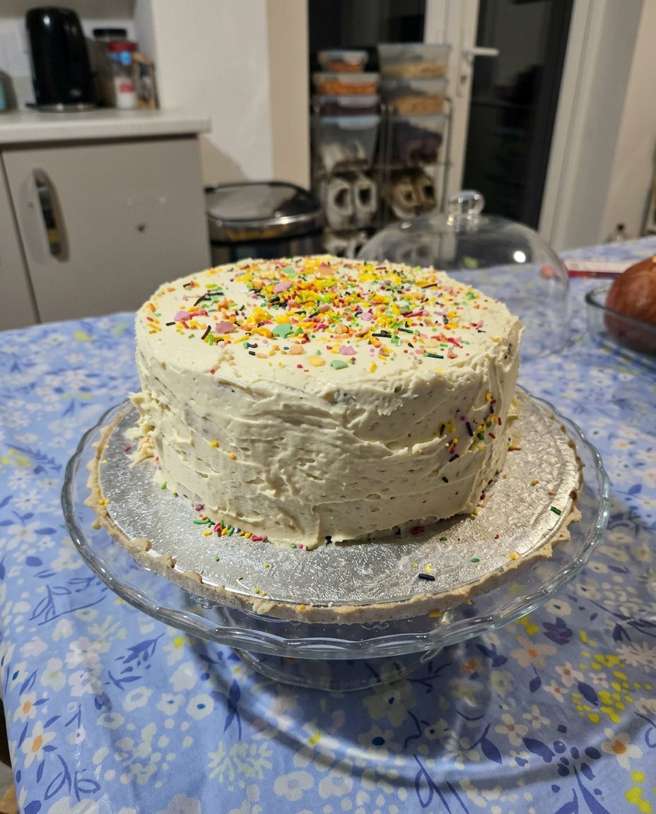 A clean slice of vanilla cake with chocolate frosting on a china plate
