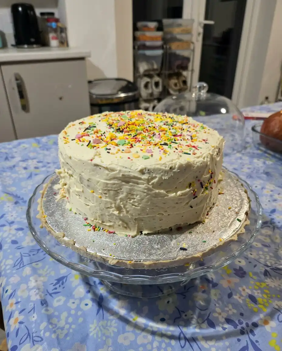 A clean slice of vanilla cake with chocolate frosting on a china plate